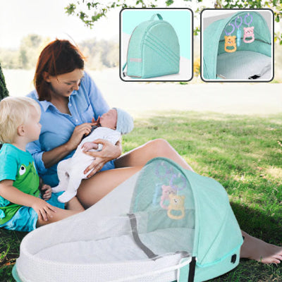 maman avec enfants et lit de voyage bébé