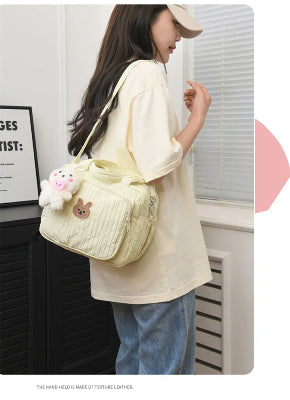 sac à langer jaune avec pendentif ourson porté sur épaule