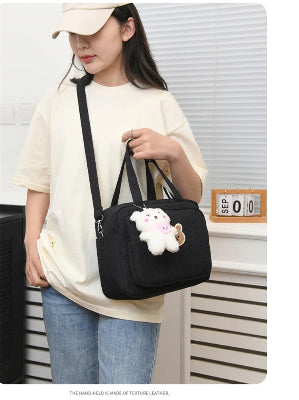 sac à langer noir sur épaule et main